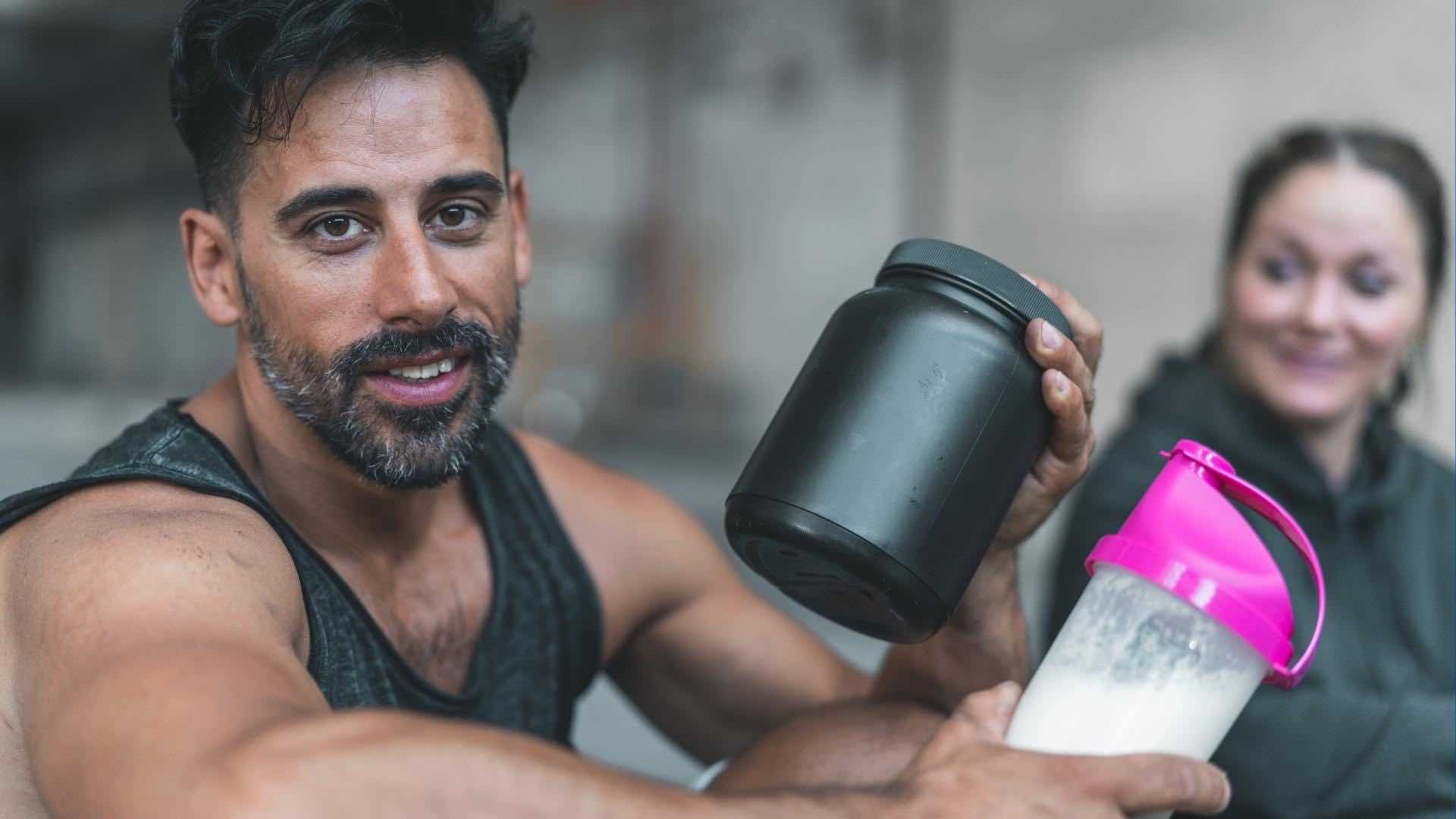 man holding a bottle of the best lactose free protein powder